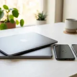 清潔な白いデスクに置かれた2台のよく似たスマートフォン。一方はブランドロゴがあり、もう一方は無地。製造の仕組み（OEM）を表現している。明るい自然光のプロフェッショナルな写真。