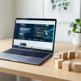 清潔な白いデスクに置かれたノートパソコン。その横には、いくつかの同じ形の木製ブロックが円を描くように並んでおり、上下関係のない自律的な組織（ホラクラシー）を表現している。