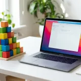 清潔な白いデスクに置かれたノートパソコン。その横には、積み木で作られた綺麗なピラミッドがあり、結論を支える根拠の構造（ピラミッドストラクチャー）を表現している。明るい自然光のプロフェッショナルな写真。
